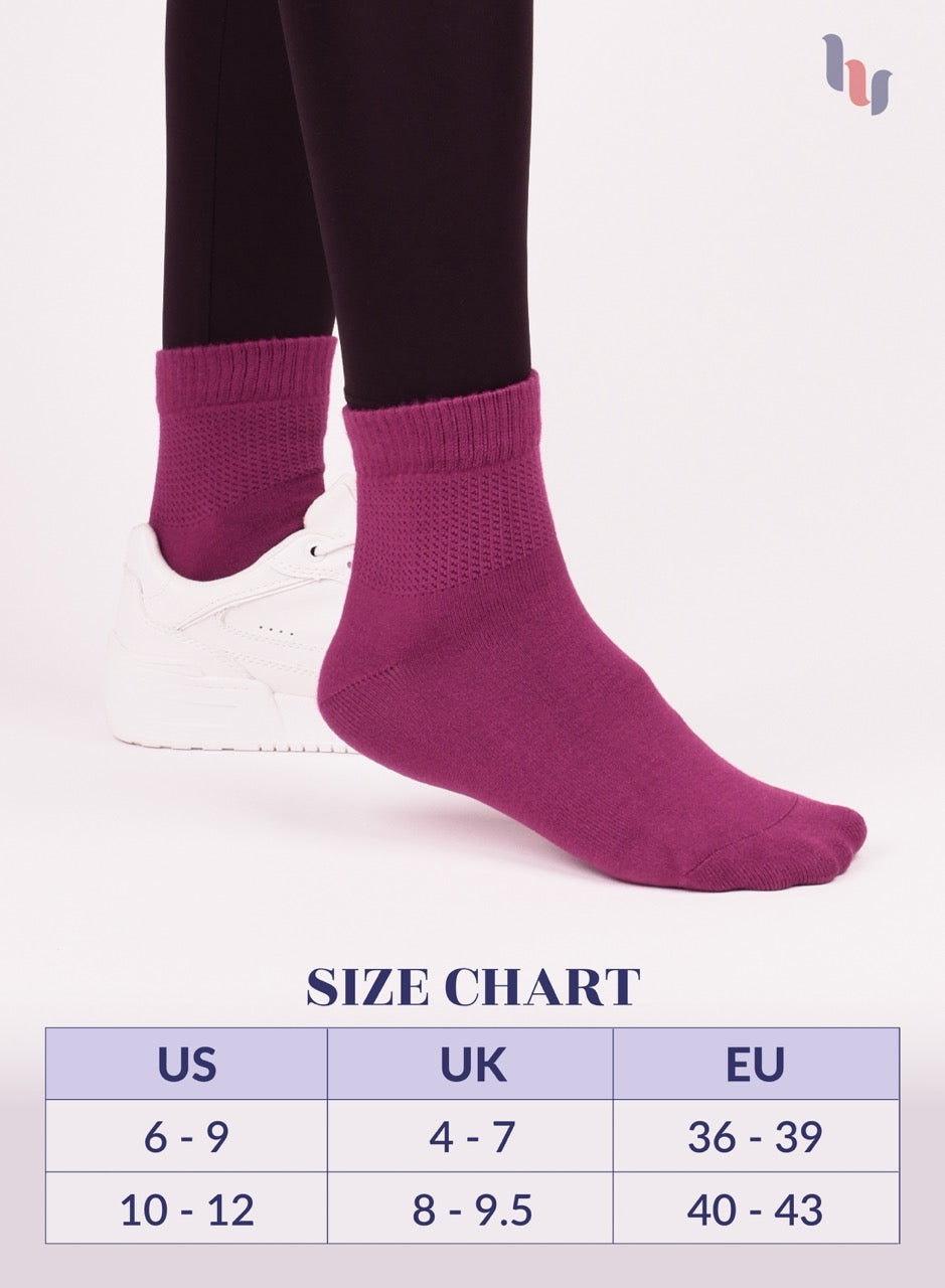 fuchsia socks being worn with a size chart below on a white background