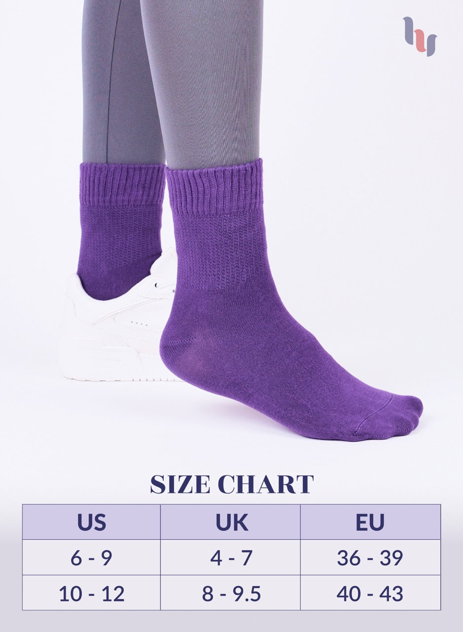 Purple socks being worn with a size chart below on a white background
