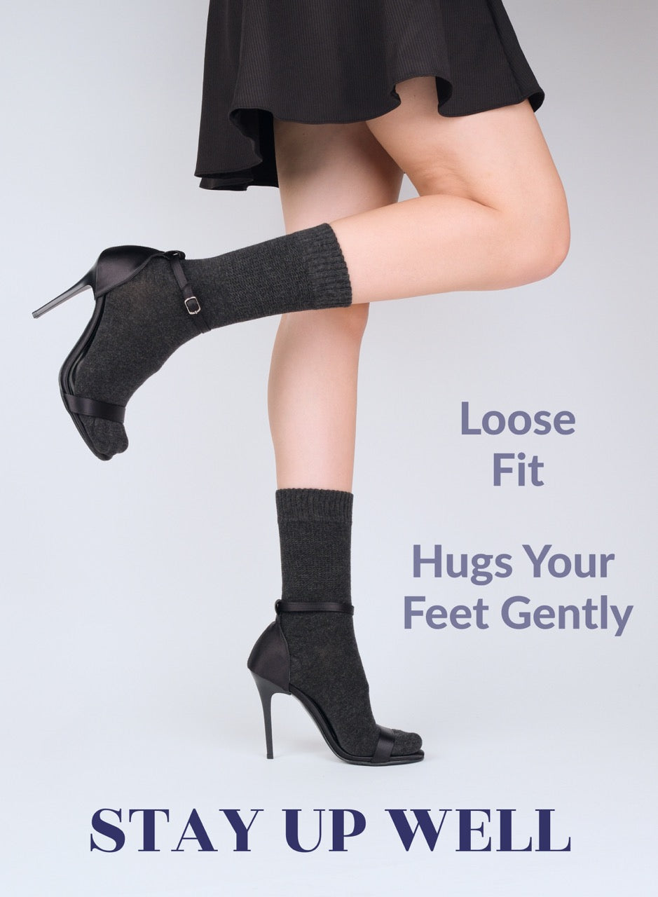 Person wearing Charcoal and high-heeled shoes and socks with text about sock fit on a light gray background