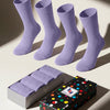 Four pairs of aster purple socks with a colorful polka dot gift box on a light background