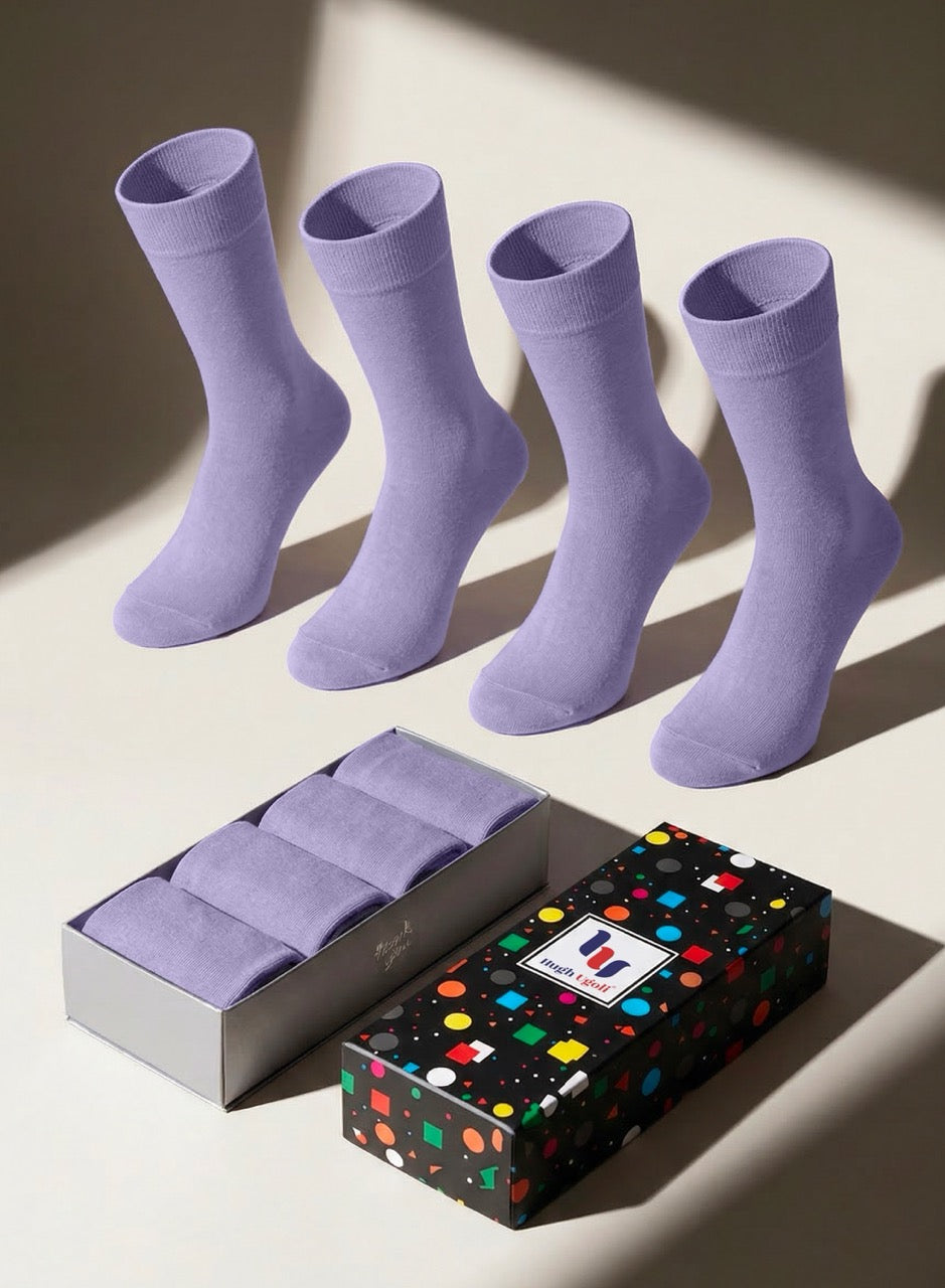 Four pairs of aster purple socks with a colorful polka dot gift box on a light background