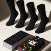 Four black socks with a colorful polka dot box on a light background