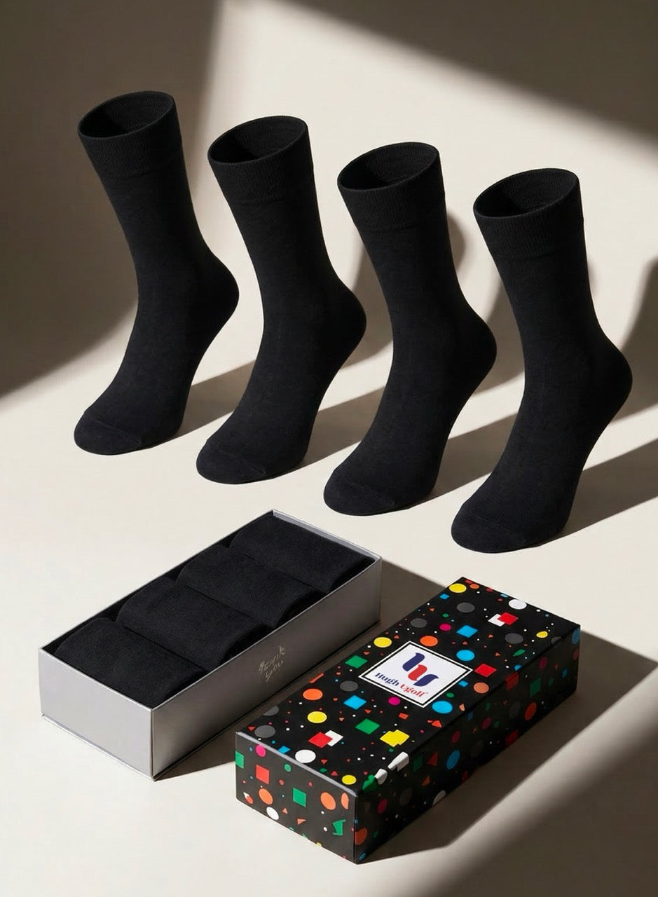 Four black socks with a colorful polka dot box on a light background