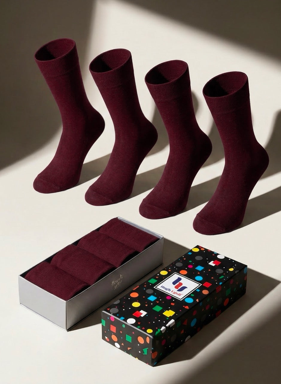 Four burgundy socks with a patterned gift box on a light background
