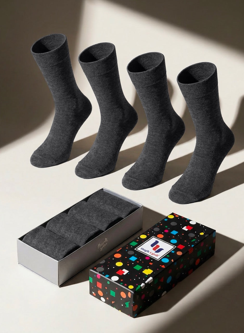 Four charcoal socks with a patterned gift box on a light background