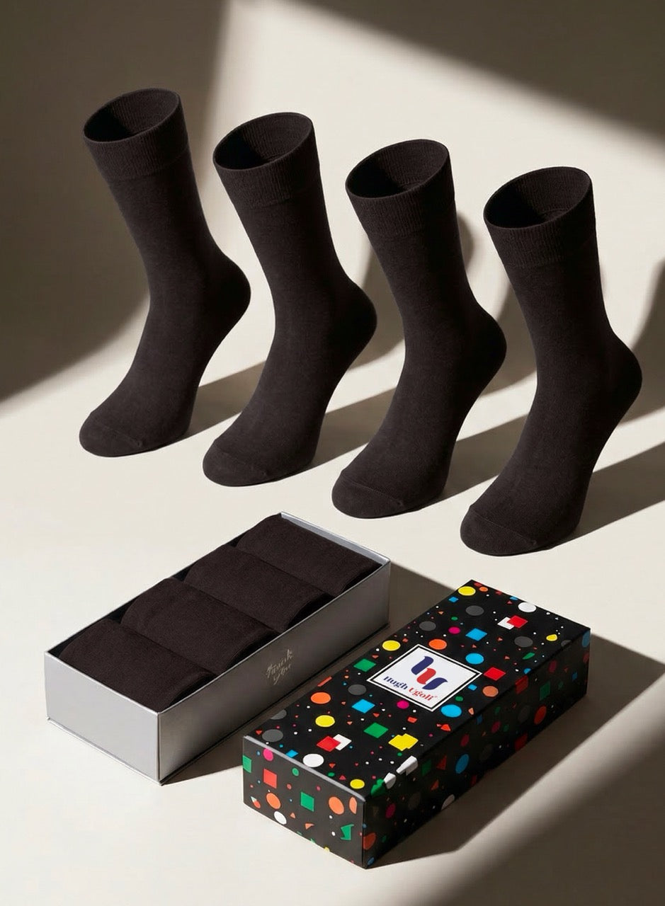 Four dark brown socks with a colorful polka dot box on a light background