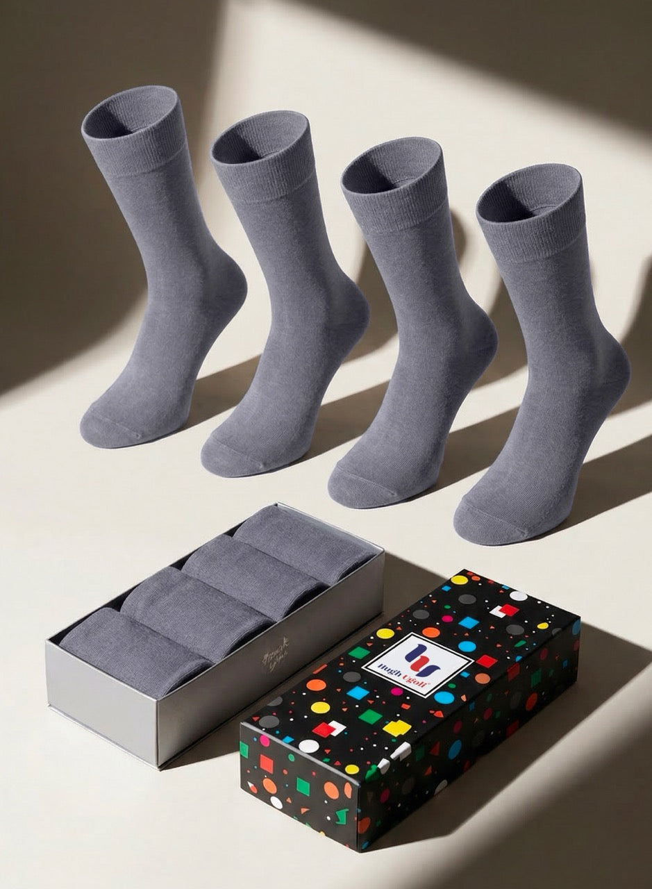 Four gray socks with a box featuring a colorful polka dot pattern on a light background