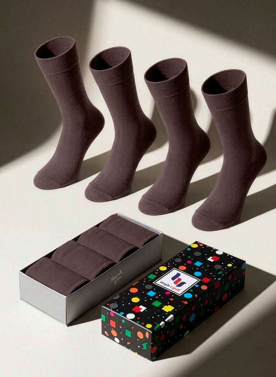 Four pairs of light brown socks with a branded box on a light background
