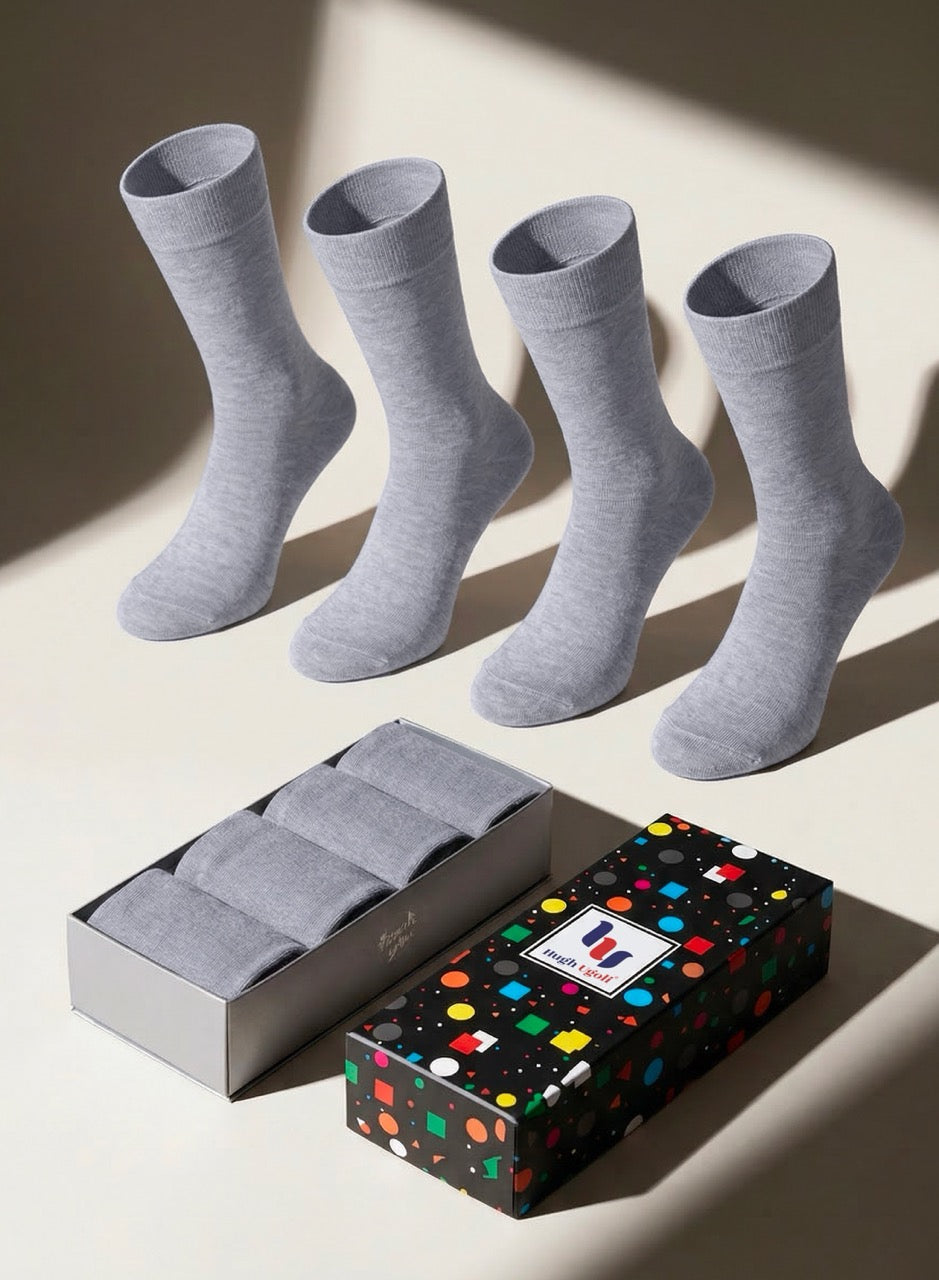 Four light gray socks with a colorful patterned box on a light background