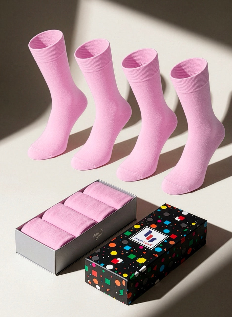 Set of pink socks with a box and colorful packaging on a light background