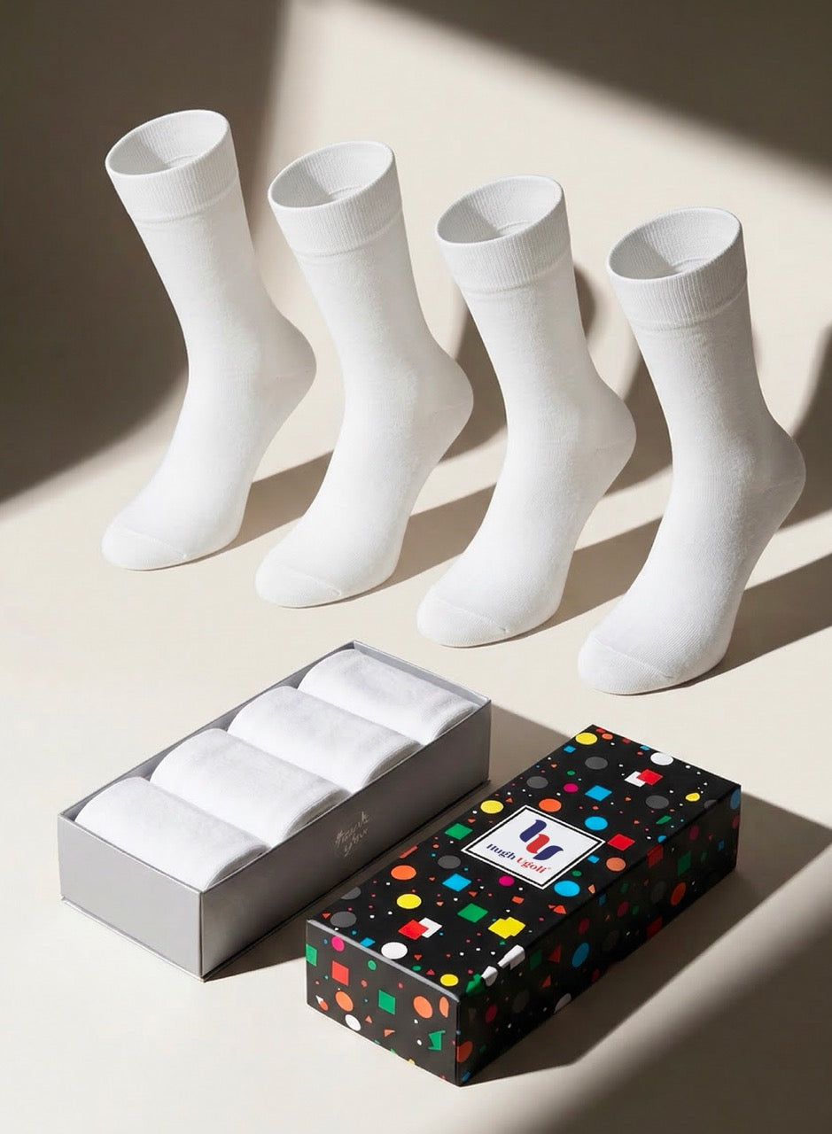 Four white socks with a colorful polka dot box on a light background