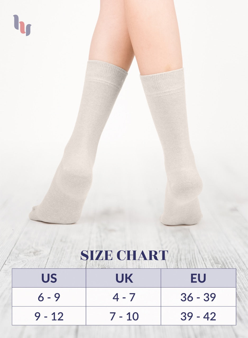 Light Beige crew socks on a person's legs with a size chart below on a white background
