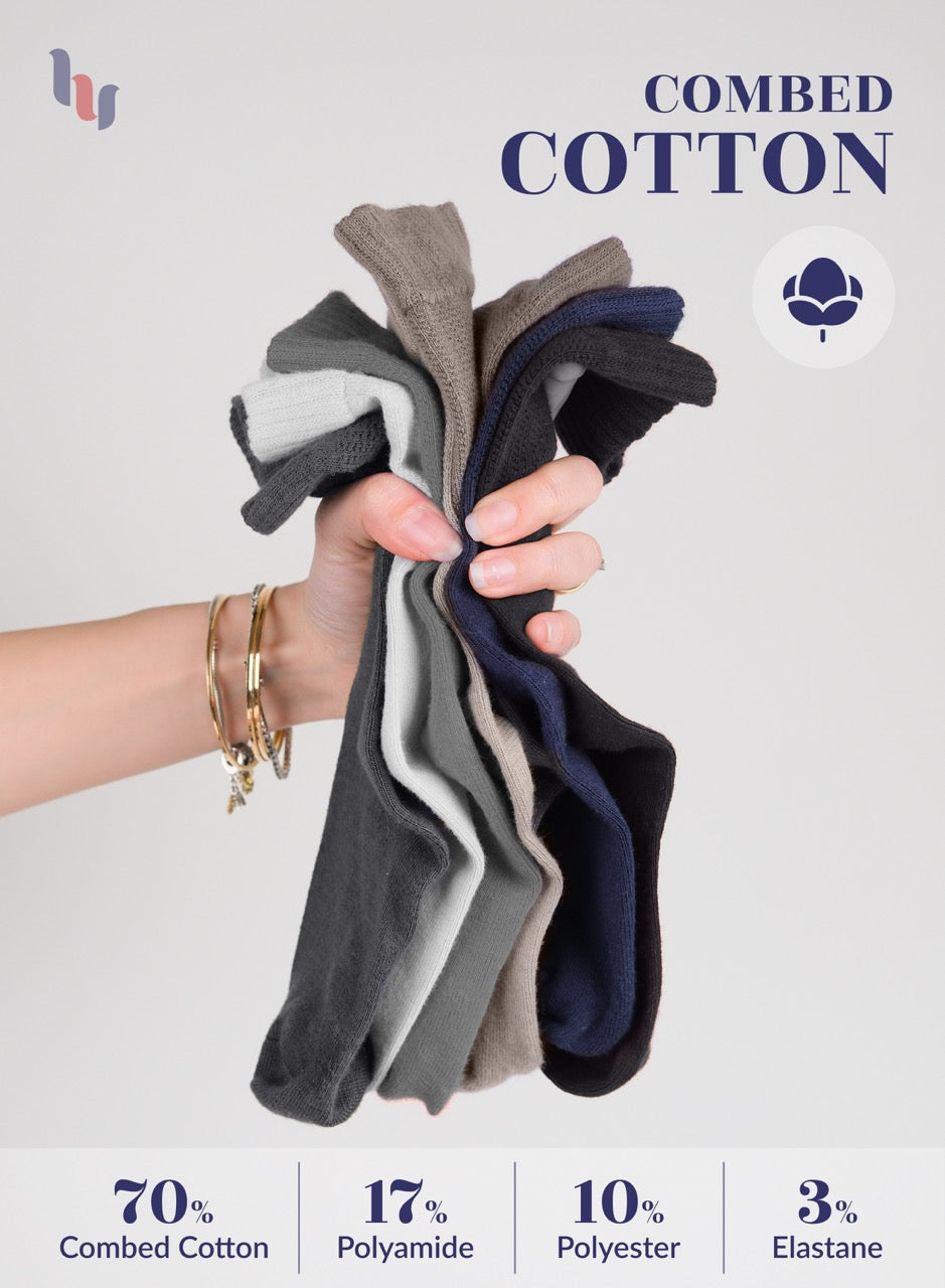 Hand holding a bundle of combed cotton socks with product details on a light gray background