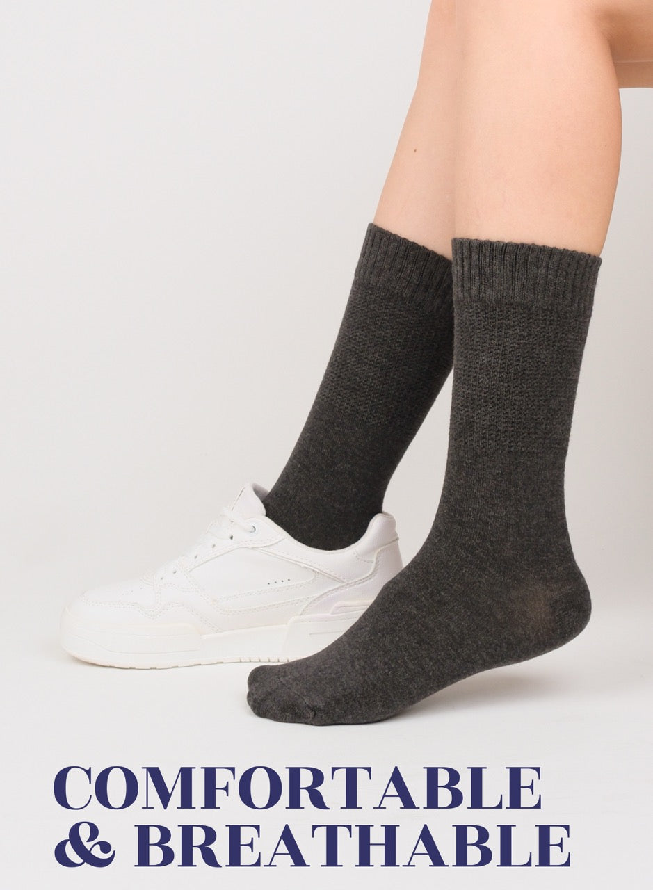 Person wearing charcoal socks with text 'Comfortable & Breathable' on a light background