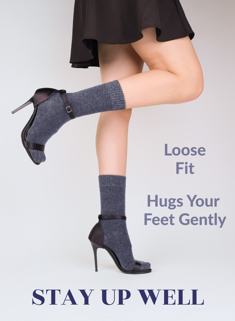 Person wearing indigo blue socks with black high-heeled shoes on a white background, with text about sock fit.