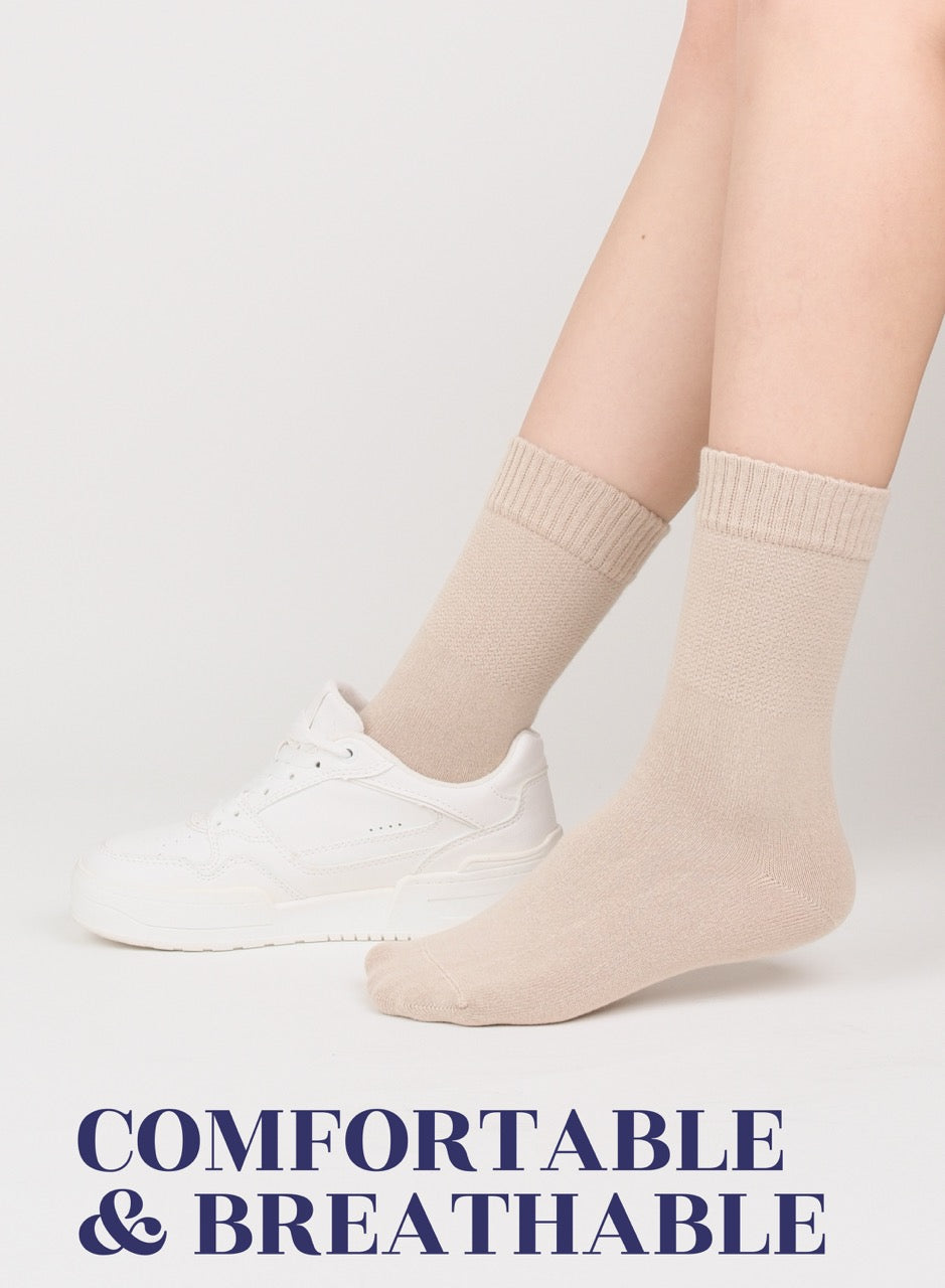 light Beige socks worn with white sneakers on a light gray background