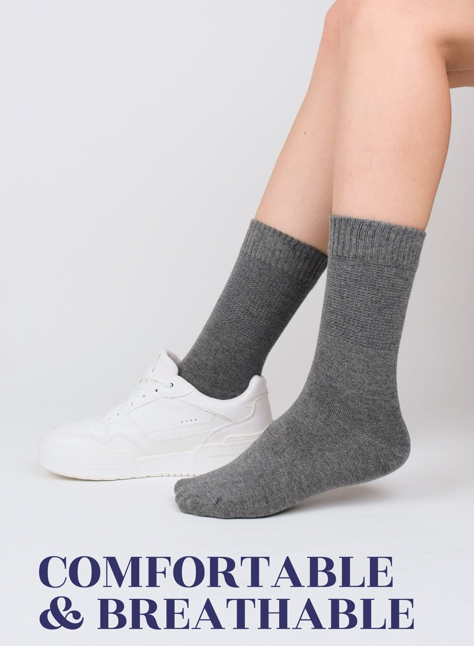 Person wearing melange gray socks with text 'COMFORTABLE & BREATHABLE' on a light background