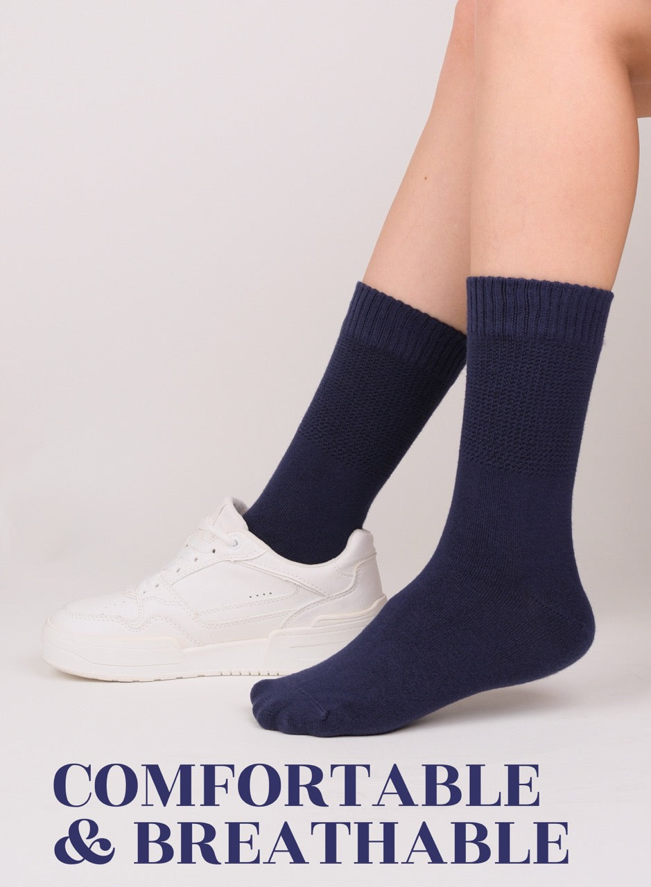 Navy blue socks worn with white sneakers on a light gray background