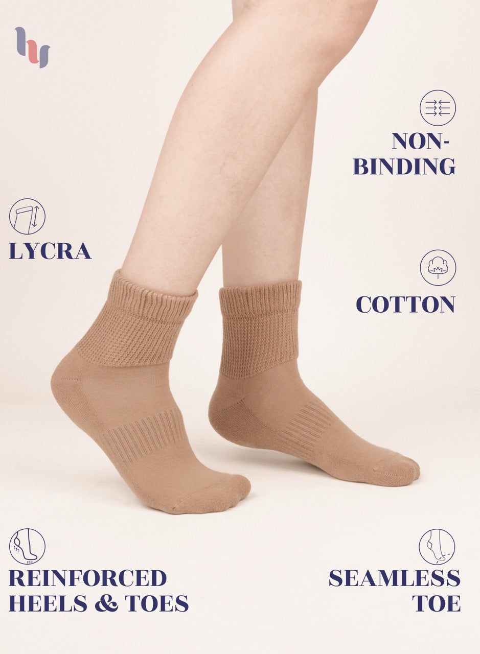 Beige socks worn by a person on a white background with text highlighting features like LYCRA, non-binding, cotton, reinforced heels & toes, and seamless toe.