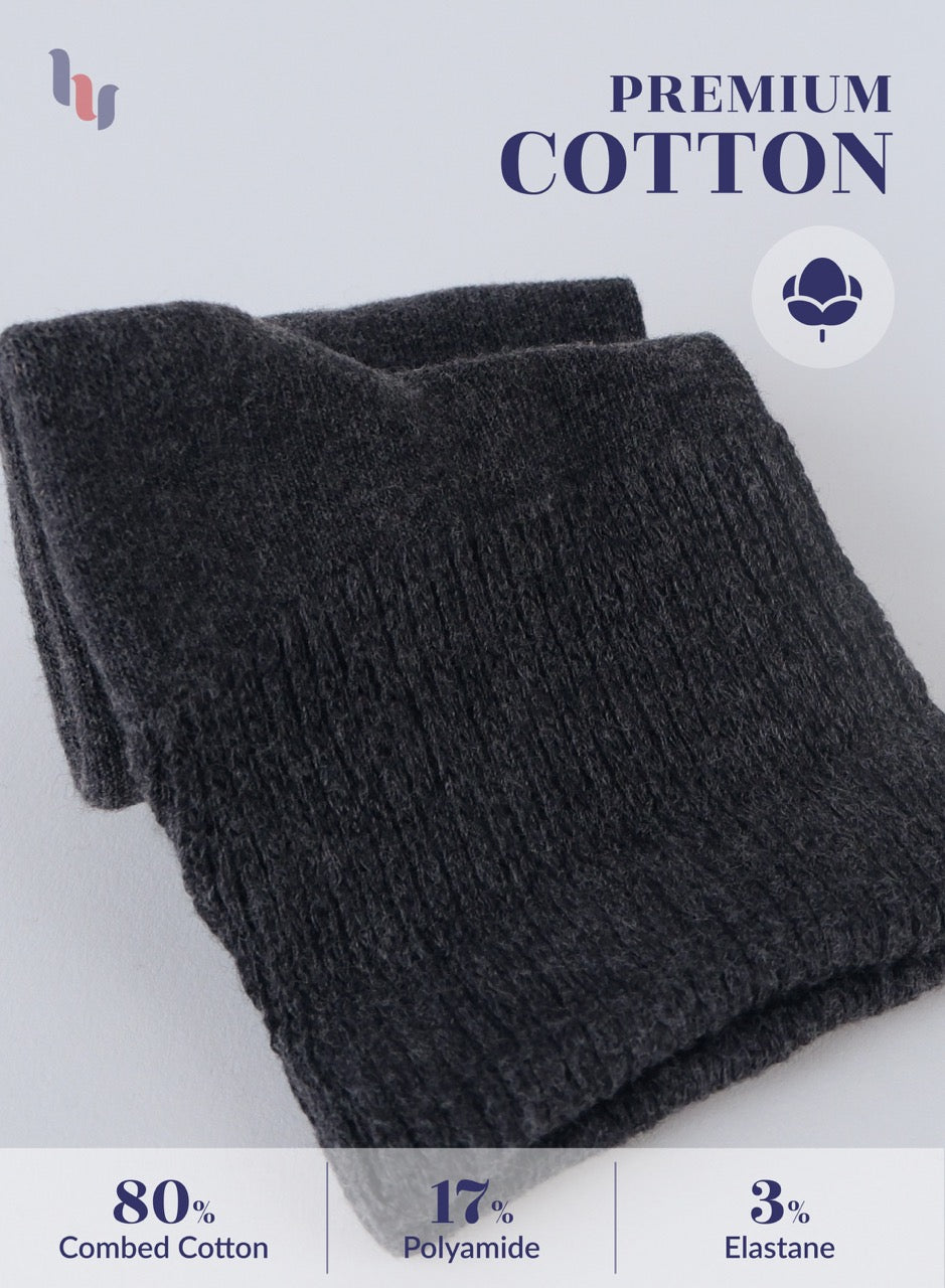 Folded dark gray sweater with 'Premium Cotton' label and fabric composition details on a light background