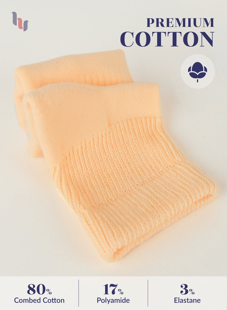 Folded Pastel peach fabric with 'Premium Cotton' label and material composition details on a white background