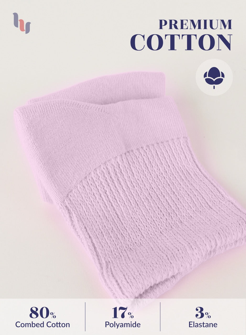 Pastel pink knitted blanket with 'Premium Cotton' label and fabric composition details on a light background