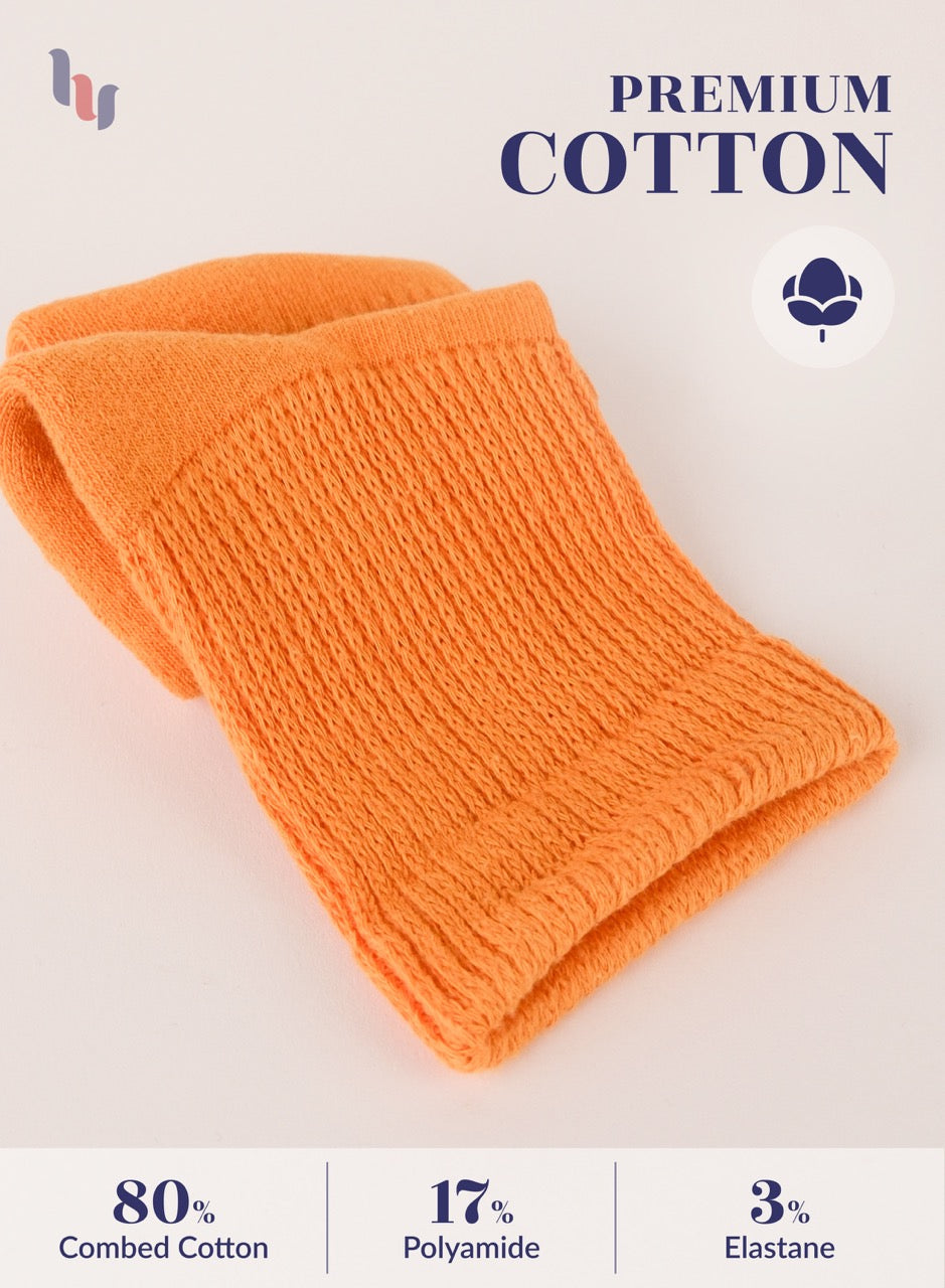 Pumpkin Orange knitted fabric with 'Premium Cotton' label and material composition details on a light background