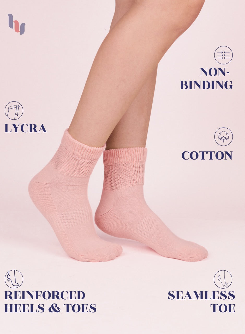 Rose cloud socks worn by a person on a light pink background with text highlighting features like Lycra, non-binding, cotton, reinforced heels & toes, and seamless toe.