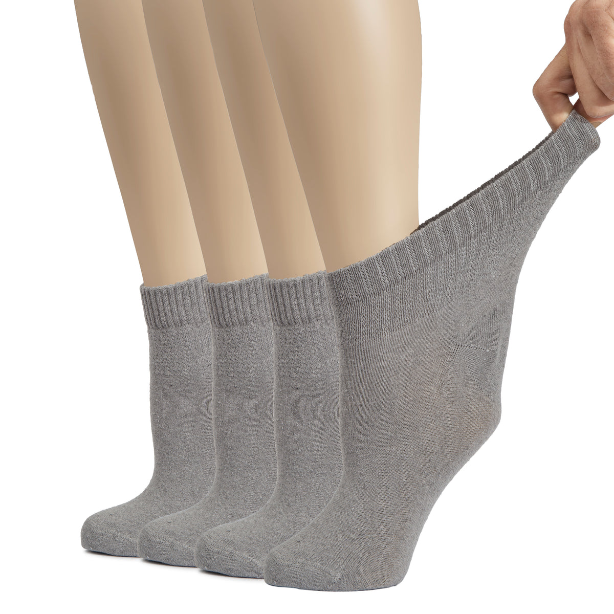 A photo of a woman's feet in grey socks, one foot raised. The socks are Women's Cotton Diabetic Ankle Socks, designed for comfort and support.