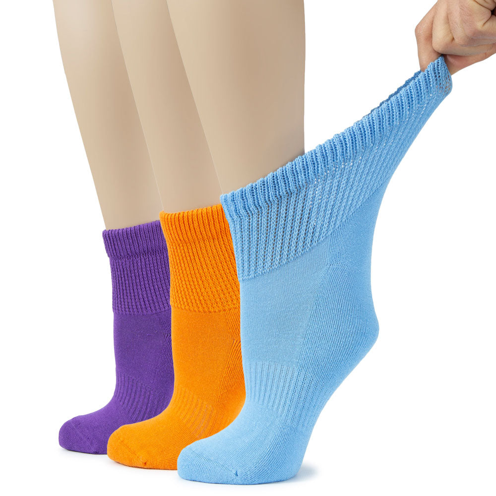 A person holds three pairs of Women's Cotton Diabetic Ankle Socks in purple, orange, and blue, showcasing their vibrant colors.